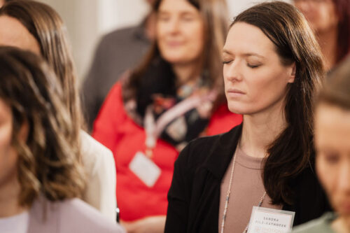 Teilnehmerin hört konzentriert zu, Augen zu, bei einem EMOTIONS Community Event