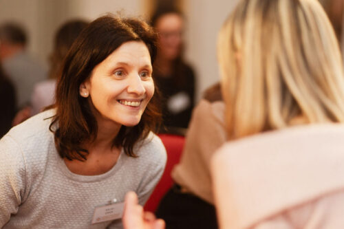 Lächelnde Teilnehmerin im Dialog bei einem EMOTIONS Community Event